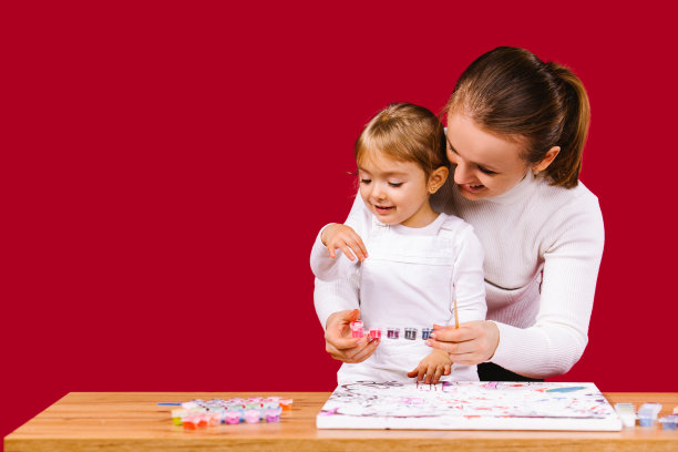 绘画的数字。年轻的妈妈和她的女儿喜欢用数字着色图片。创造性的爱好。自我隔离期间的居家休闲活动图片下载