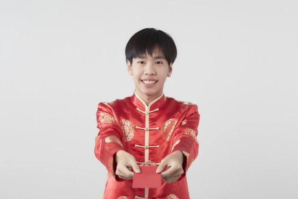 年轻的亚洲男子在普通话领连衣裙拿着红包在白色的背景图片下载