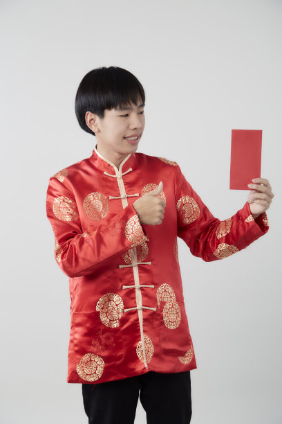 年轻的亚洲男子在普通话领连衣裙拿着红包在白色的背景图片下载