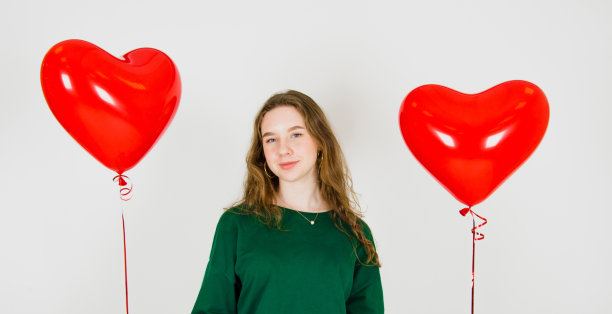 白色背景下拿着气球的女孩。庆祝生日、情人节、妇女节的概念图片下载