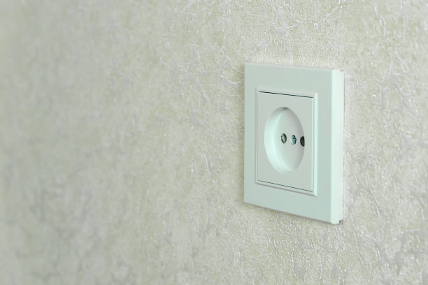 白色的电源插座上的白色墙壁特写与复制空间，照片的一个角度图片下载