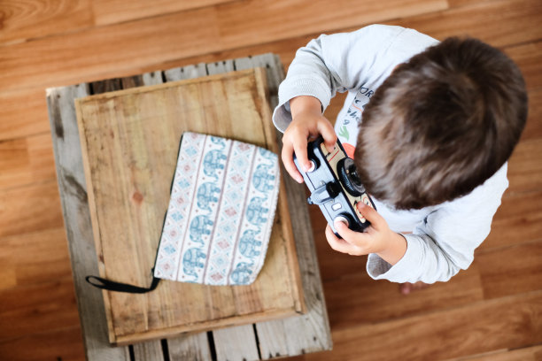 一个蹒跚学步的小男孩在练习如何使用照相机图片下载