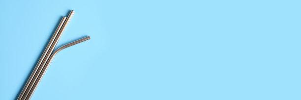 可重复使用的金属不锈钢吸管，蓝色背景。空间的文本。横幅图片下载