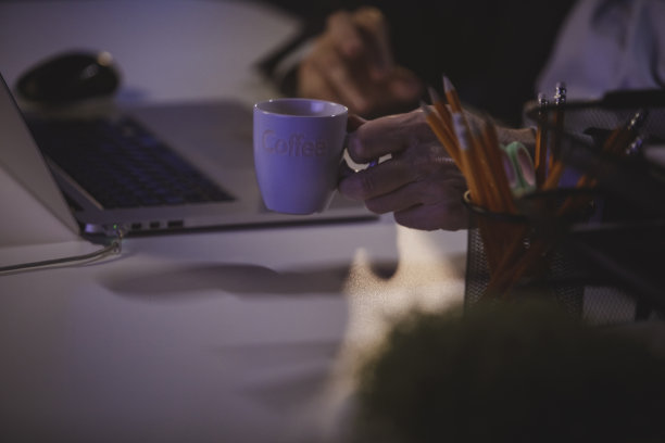 工作到很晚的商人伸手去拿咖啡图片下载