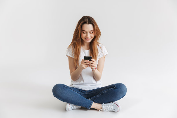 一个快乐的年轻女孩使用手机的肖像图片下载