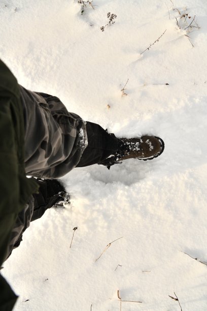 猎人穿着一双耐雪和冰的鞋在雪地里行走图片下载