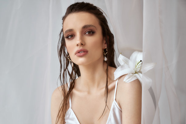 女孩与百合摆姿势的肖像。图片下载