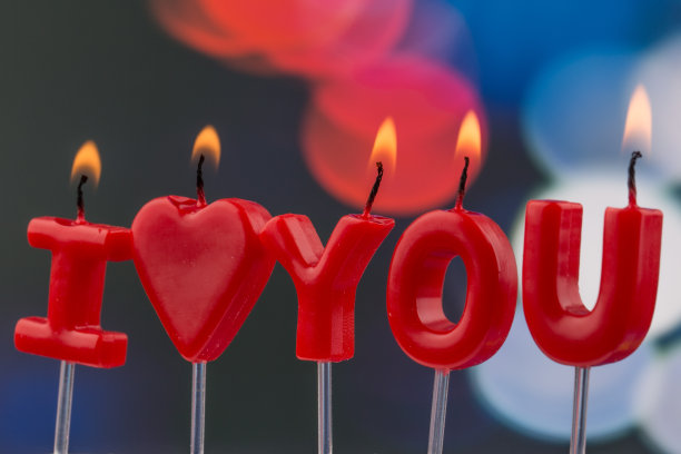 燃烧着的红色蜡烛把“我爱你”孤立起来。图片下载