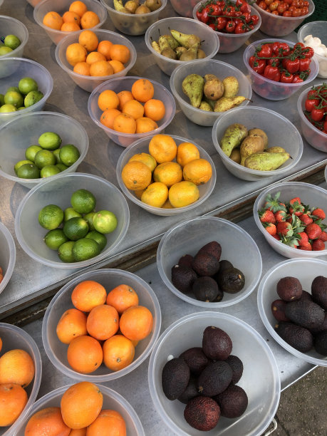绿色食品店展示的图片称好并放在塑料碗里的新鲜水果，包括梨、番茄、草莓、酸橙、牛油果和橙子，高架视图、Covid-19法规、高架视图图片下载