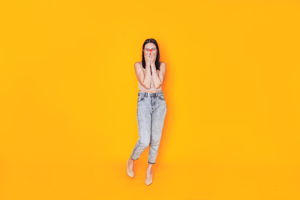 年轻女子站在黄色背景前。优秀的横幅广告图片。卫生保健。在家自己化妆图片下载