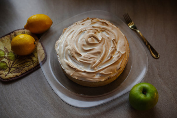 柠檬蛋白派放在切菜板上，以棕色的木头为背景图片下载