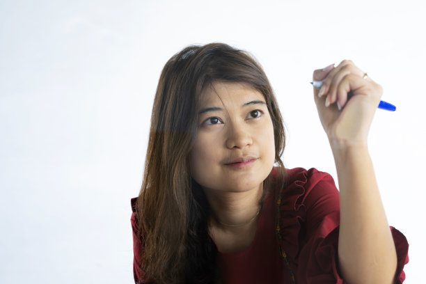 亚洲商业女性正在工作中对着镜子写战略构想。图片下载