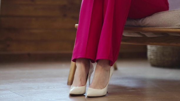 疲惫的女商人在漫长的一天后脱下了鞋子。高跟鞋后脚部肿胀，软焦点。有选择性的重点图片下载