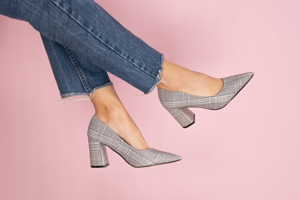 腿上穿着时尚的高跟鞋，彩色背景与复制空间。女人身体部分的特写照片。图片下载