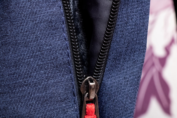 黑色拉链上的蓝色袋子特写图片下载