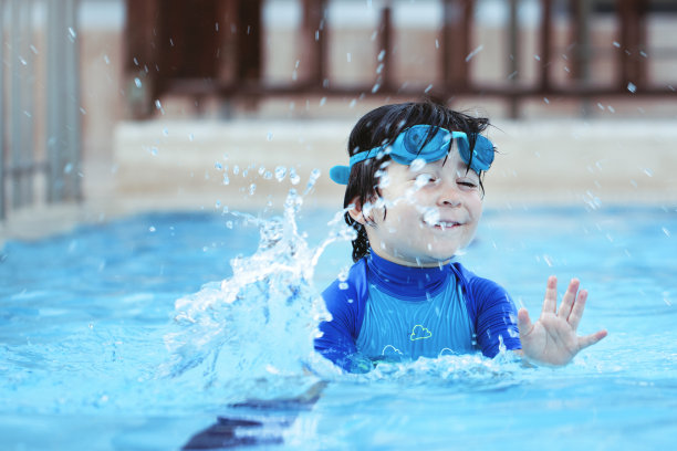 快乐的小男孩在游泳池里享受夏日时光图片下载