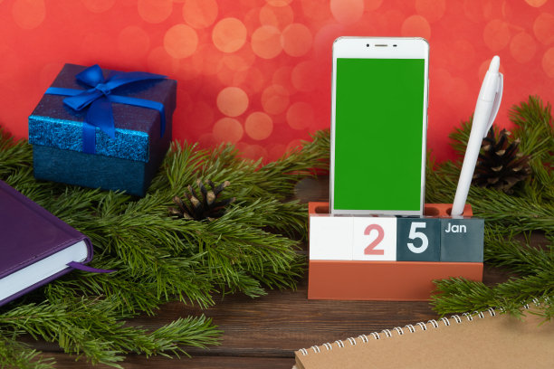 桌面日历，日期1月25日和一部手机。一天的计划。在电话屏幕上插入图像的布局。本空间图片下载
