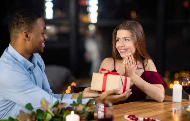 浪漫的惊喜。一名黑人在餐馆里给女朋友送礼物图片下载