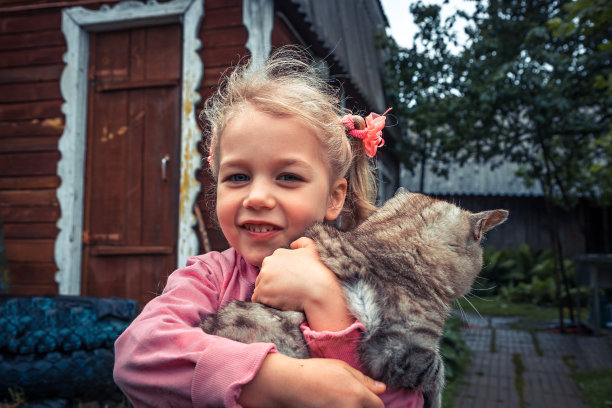 快乐微笑的小女孩拥抱猫户外概念快乐的童年生活方式图片下载