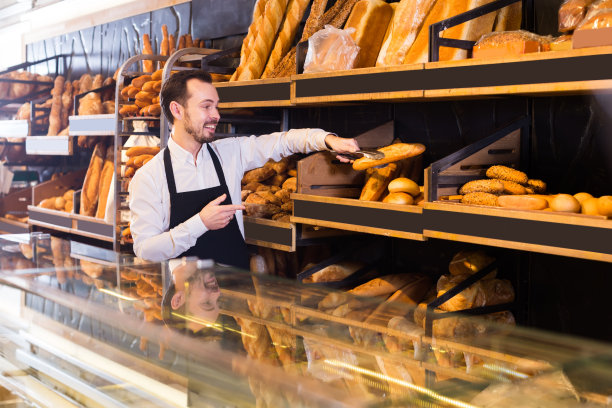 售货员提供长棍面包和长面包图片下载