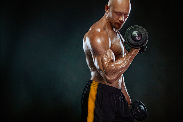 强壮健美的男子健美运动员。运动健将，拿着哑铃。运动和健身动机。个人运动娱乐。图片下载