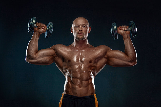 强壮健美的男子健美运动员。运动健将，拿着哑铃。运动和健身动机。个人运动娱乐。图片下载