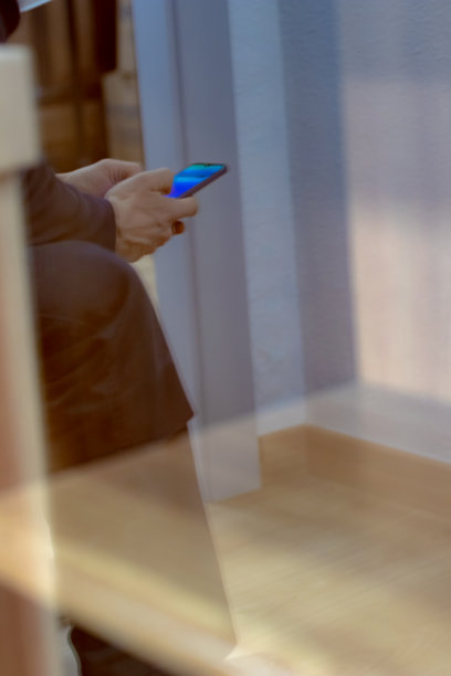 一个男人拿着手机在候机室等在机场火车站的镜子里图片下载