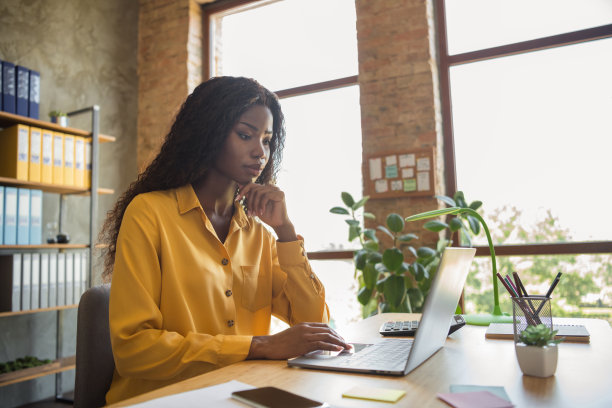 非裔美国妇女的侧面照片工作办公室笔记本电脑认真执行在办公室室内工作空间图片下载