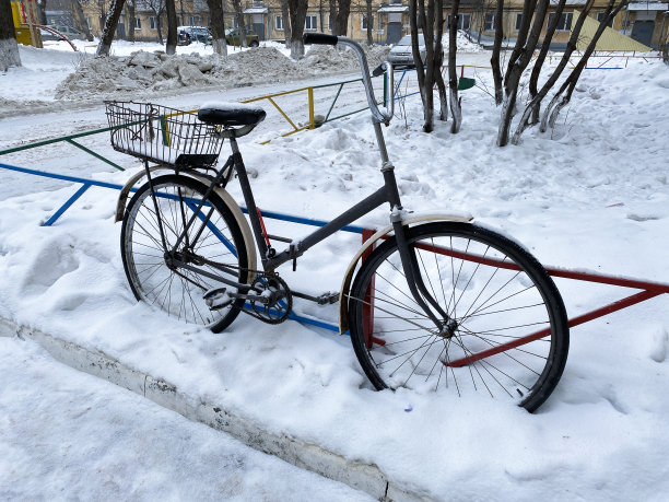 自行车与篮子覆盖的雪在街上，冬季季节。大雪风暴。图片下载