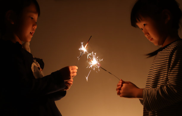 两个微笑的亚洲女孩在中国新年玩烟花图片下载