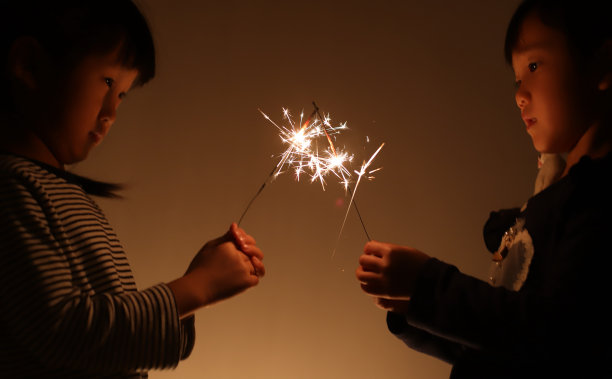 两个微笑的亚洲女孩在中国新年玩烟花图片下载