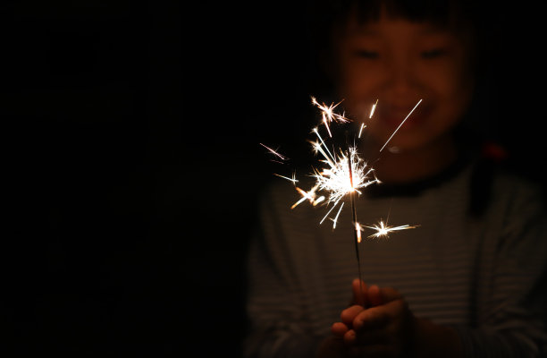 两个微笑的亚洲女孩在中国新年玩烟花图片下载