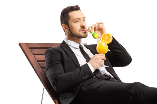 商人躺在日光浴床上喝着鸡尾酒图片下载