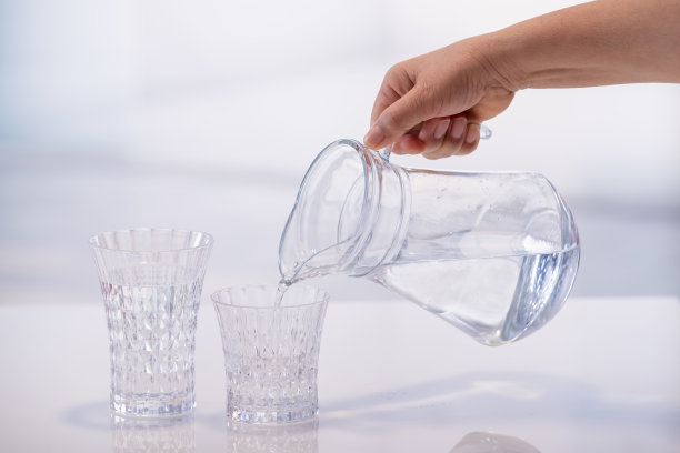 用手把水从罐子倒进玻璃杯里图片下载