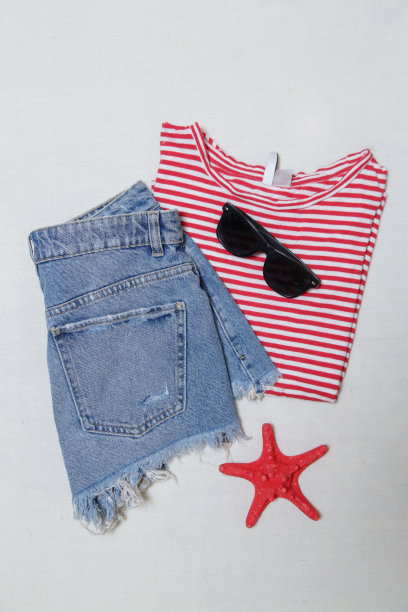 简单的夏装，牛仔短裤和条纹棉布衬衫配上白色的配饰。女士休闲时尚单品，俯视图。图片下载