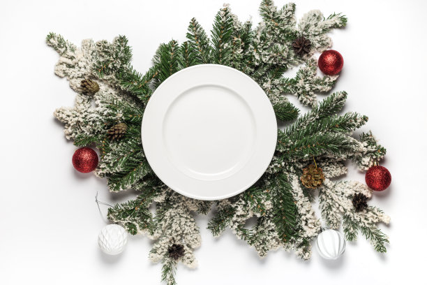 空白色陶瓷板与杉木枝和装饰。平lay圣诞和新年的概念。俯视图图片下载