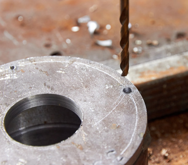 钻床上的金属制品和钻头图片下载