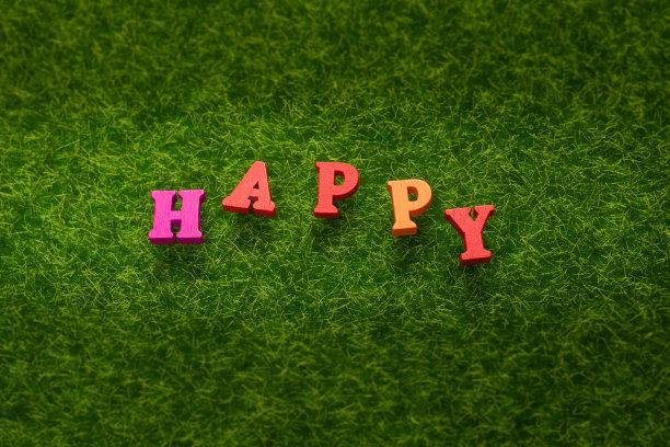 快乐文字上一片绿草。图片下载