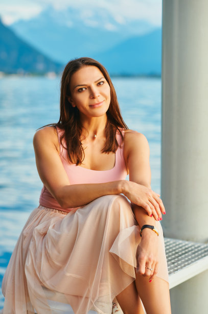 户外肖像美丽的年轻女子休息在湖边，健康的生活方式图片下载