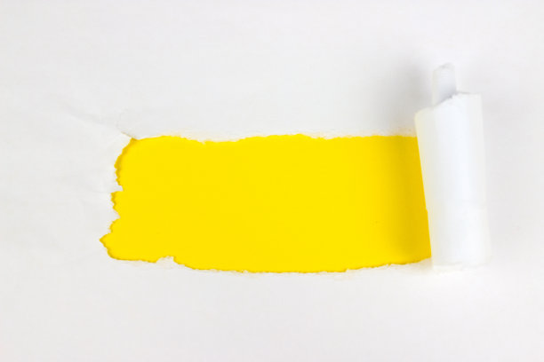 黄色背景上两面撕破的白纸上的洞。图片下载