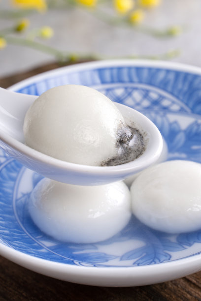 特写的元宵汤圆在一个碗在灰色的桌子上，食物为中国元宵节。图片下载