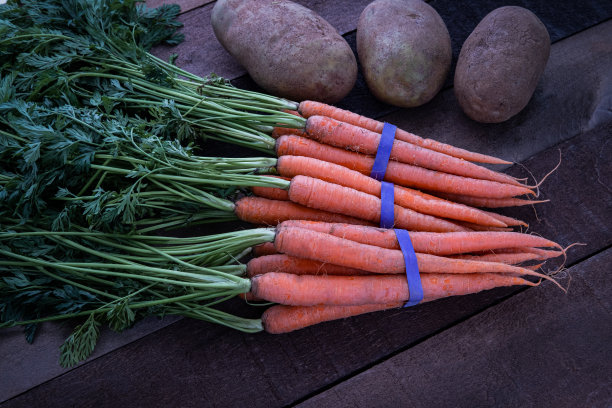 木桌上有机胡萝卜和土豆的照片图片下载