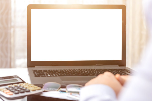 一个商人看着他办公桌上的笔记本电脑的空白屏幕图片下载