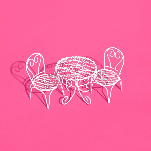 亮粉色背景上的白色金属椅子和桌子。创意时尚的布局与阳光和坚硬的阴影。咖啡馆、餐厅、夏日简约概念图片下载