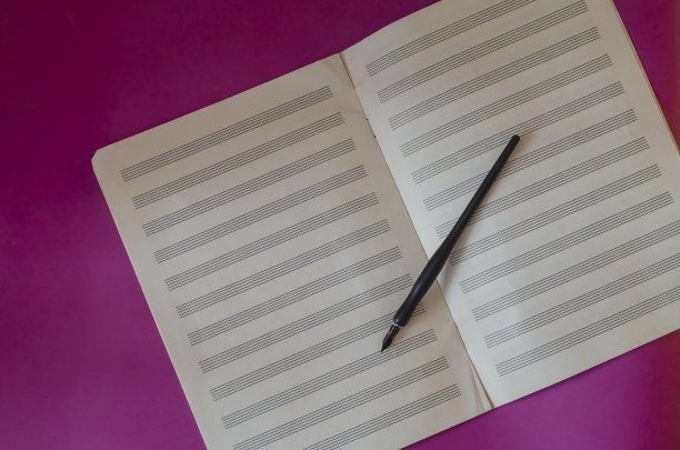 黑色钢笔和打开音乐笔记本在紫色的背景。图片下载