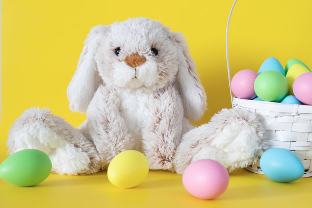 复活节兔子与彩色的蛋和篮子在粉红色的背景图片下载