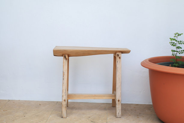 长凳和树靠白墙，原木木制的居家风格长凳。城市改善，城市规划，公共空间。图片下载
