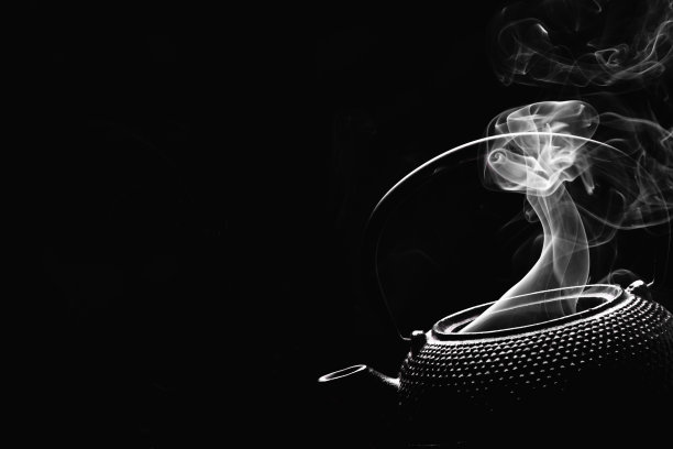 古董茶壶。黑色背景上热气腾腾的茶壶。烹饪概念。图片下载