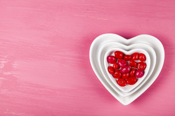 红色糖果放在一个心形的盘子里图片下载