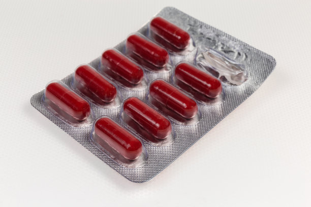 红色胶囊在开始的泡罩包装在浅色表面图片下载